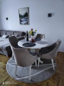 een witte tafel en stoelen in de woonkamer bij Splendid J&R apartman in Bijeljina