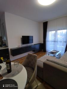 een woonkamer met een bank en een tafel bij Splendid J&R apartman in Bijeljina