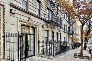 a building with a wrought iron door on a street at Modern Upper West Side Private Room by Central Park in New York