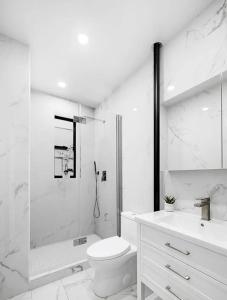 a bathroom with a shower and a toilet and a sink at Modern Upper West Side Private Room by Central Park in New York