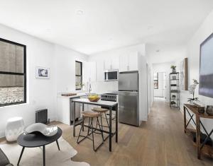 a kitchen with white walls and stainless steel appliances at Modern Upper West Side Private Room by Central Park in New York