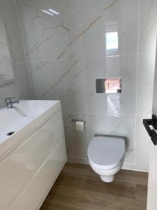 een witte badkamer met een toilet en een wastafel bij Sea View urban apartment in Faro +13 foto's