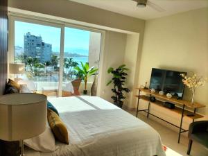 a bedroom with a large bed and a large window at Casa Cielo V-Bucerias in Bucerías