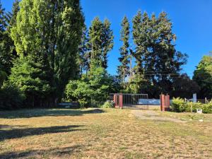 a park with a fence and trees in the background at Cabaña Tranquilidad en Familia in Chillán