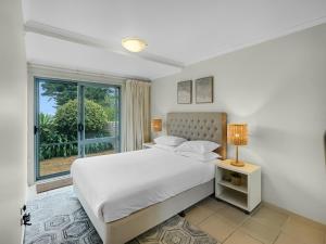 a white bedroom with a bed and a window at 2-Bed Townhouse with Outdoor Area in Long Beach
