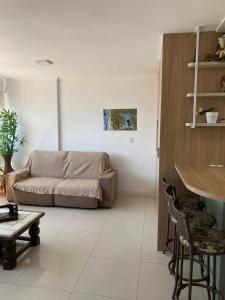 a living room with a couch and a table at Apê da Paula in Torres