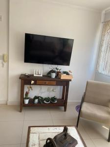 a living room with a flat screen tv on a wall at Apê da Paula in Torres