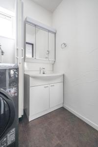 een witte badkamer met een wastafel en een spiegel bij Pregio Asahikawa in Asahikawa +86 foto's
