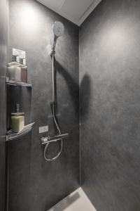 een douchecabine met een douchekop aan de muur bij Pregio Asahikawa in Asahikawa