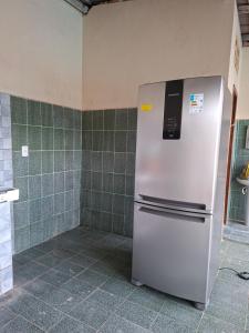 a refrigerator in a kitchen with green tiles at Residencial Paraviana-Casa Piscina in Boa Vista