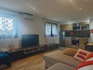 een woonkamer met een bank en een grote televisie bij INSPIRA MAISON Montaña y Mar in Teià