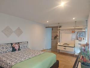 een slaapkamer met een bed en een badkamer met een wastafel bij INSPIRA MAISON Montaña y Mar in Teià