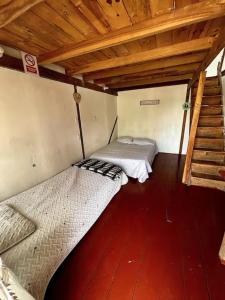 a small room with two beds and a wooden floor at Cabaña Sol in Calimita +6 photos