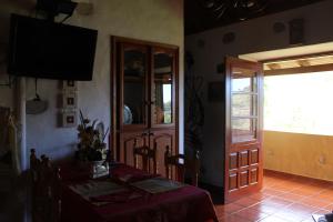 a dining room with a table and a glass door at Casa Rural Las Rosas in Agulo