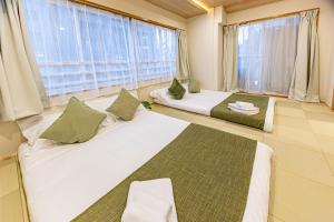 two beds in a room with a large window at New mansion 7 mins from Yoyogi stations in Tokyo