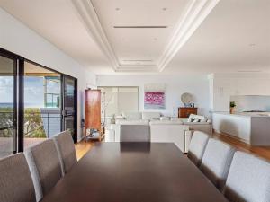 Un comedor y una sala de estar con mesa y sillas. en Ocean Views - Refined Hilltop Residence by the Sea, en Yallingup