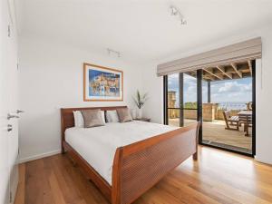 Un dormitorio con una cama grande y un balcón. en Ocean Views - Refined Hilltop Residence by the Sea, en Yallingup