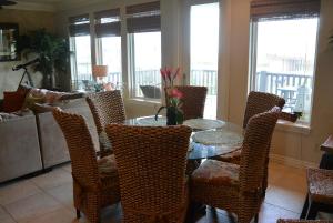 una sala da pranzo con tavolo e sedie in vetro di The Sandy Cork Home a Bolivar Beach