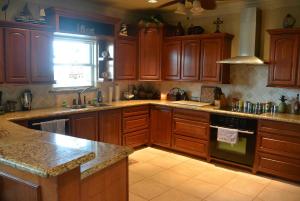 una cucina con mobili in legno e un forno a piano cottura di The Sandy Cork Home a Bolivar Beach