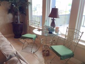 un soggiorno con tavolo e sedie in vetro di The Sandy Cork Home a Bolivar Beach Altre 4 foto