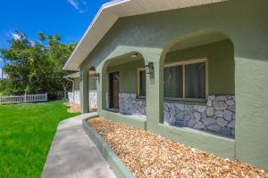 a house with a stone wall and a sidewalk at Crystal River Getaway in Crystal River