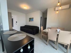 a living room with a couch and a table and chairs at Queridinho da praia de palmas in Governador Celso Ramos