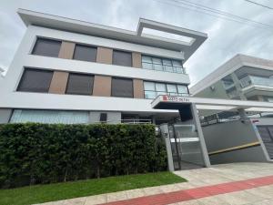 a large white building with a sign in front of it at Queridinho da praia de palmas in Governador Celso Ramos