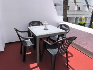 ein weißer Tisch und Stühle auf einem Balkon in der Unterkunft Amelia Cancajos - Confort Piscina y Playa cerca in Breña Baja