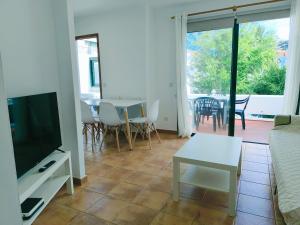 ein Wohnzimmer mit einer Couch, einem Fernseher und einem Tisch in der Unterkunft Amelia Cancajos - Confort Piscina y Playa cerca in Breña Baja