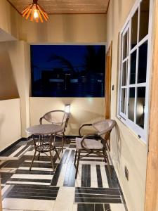 Accra Luxury Apartments At The Sanga Estates في آكرا: فناء فيه كرسيين وطاولة ونافذة