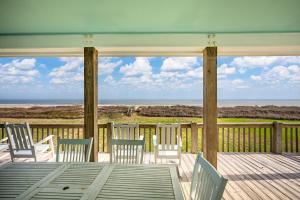 un portico con sedie e tavolo con vista sull'oceano di Lotz A View Home a Bolivar Beach