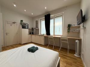 98 Apparthotel - Botanique 2 في لييج: غرفة نوم بسرير ومطبخ مع كراسي