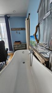 a white bath tub in a bathroom with a window at Suite 1 Flèche du fjord vue Saguenay Monts Valin in Saint-Fulgence +35 photos