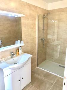 een badkamer met een wastafel en een douche bij Appartement spacieux à 10 minutes de la plage, vue mer in Menton