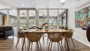 a dining room with a wooden table and chairs at Vineyard Accommodation in Dorrien