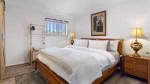 a bedroom with a large bed with white sheets at Vineyard Accommodation in Dorrien