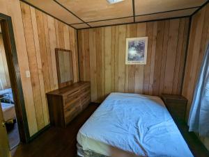a bedroom with a bed and a wooden wall at Tiny Wood Cottage 08 in Wasaga Beach