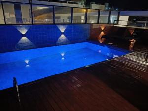 a swimming pool lit up at night at Queridinho da praia de palmas in Governador Celso Ramos