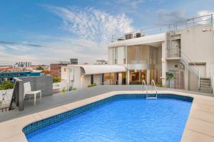an apartment with a swimming pool on the roof of a building at Swainson on Waymouth - Penthouse in Adelaide