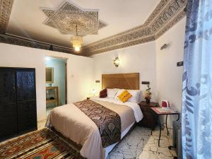a bedroom with a bed and a chandelier at Riad el Anaqa in Fez