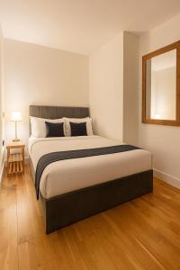 a bedroom with a large bed and a mirror at The Central Suite in Manchester
