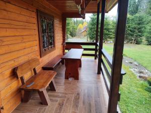 a porch of a log cabin with benches on it at Chata MOBY in Važec