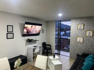 Una sala de estar con un televisor de pantalla plana en la pared. en La mejor experiencia: ubicación y comodidad, en Ibagué