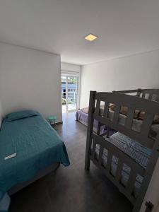 Mansão Maretti في بيرتيوغا: غرفة نوم بها سريرين بطابقين ونافذة