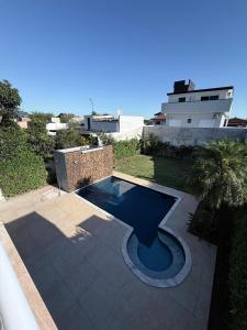 a swimming pool in the backyard of a house at Mansão Maretti in Bertioga