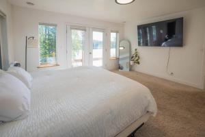 una camera bianca con un grande letto bianco e finestre di The Kenai River King a Soldotna