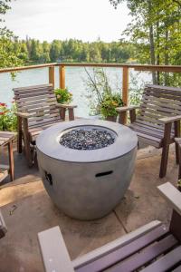 un braciere su un ponte con panchine e uno specchio d'acqua di The Kenai River King a Soldotna