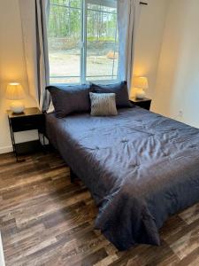 een groot bed in een kamer met een groot raam bij New Cozy Apartment in Meadow Lakes