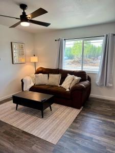 een woonkamer met een bruine bank en een salontafel bij New Cozy Apartment in Meadow Lakes