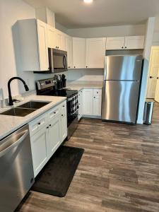 een keuken met witte kasten en een roestvrijstalen koelkast bij New Cozy Apartment in Meadow Lakes +22 foto's